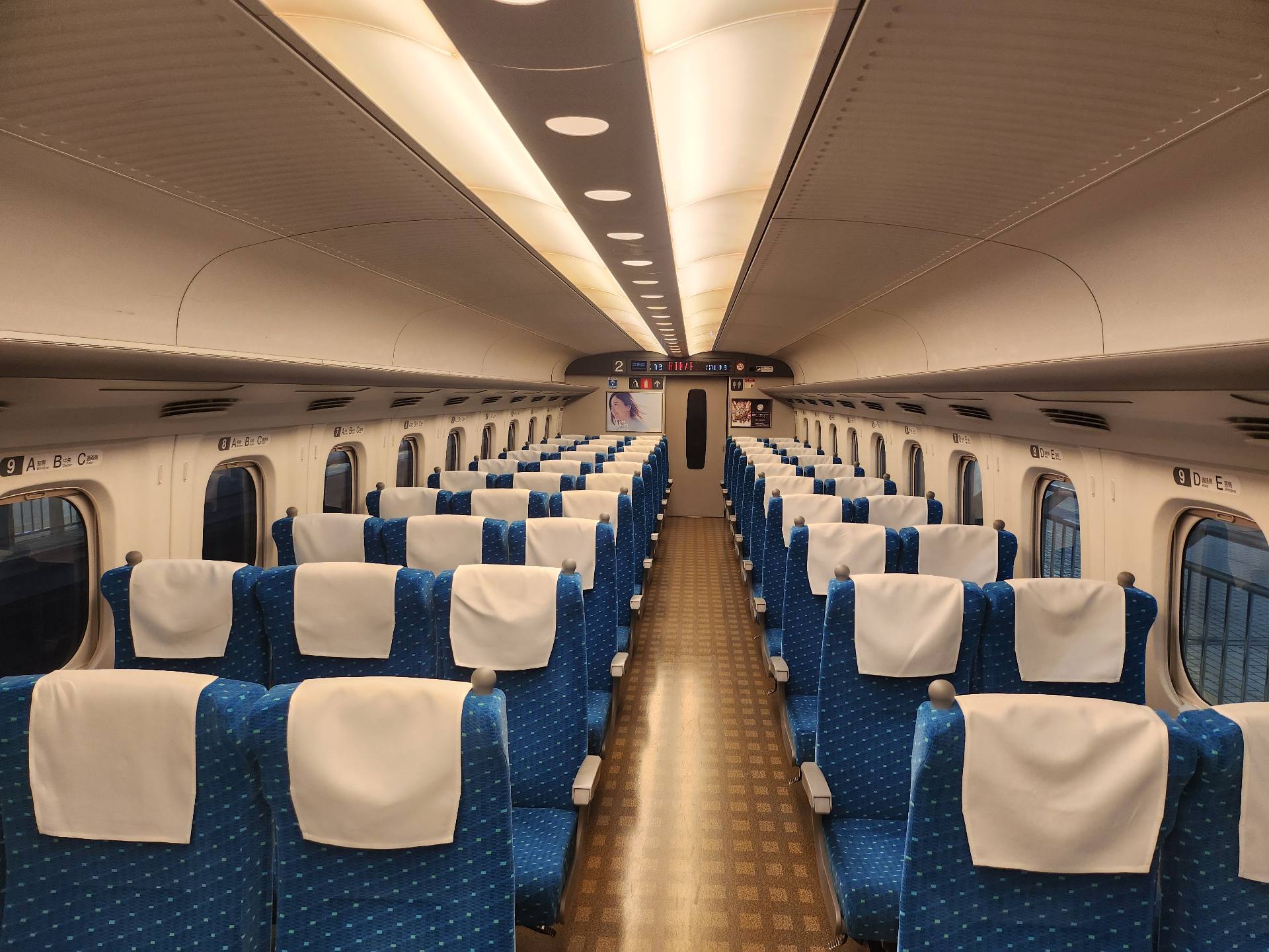 Interno del vagone Standard Shinkansen con sedili blu tre più due